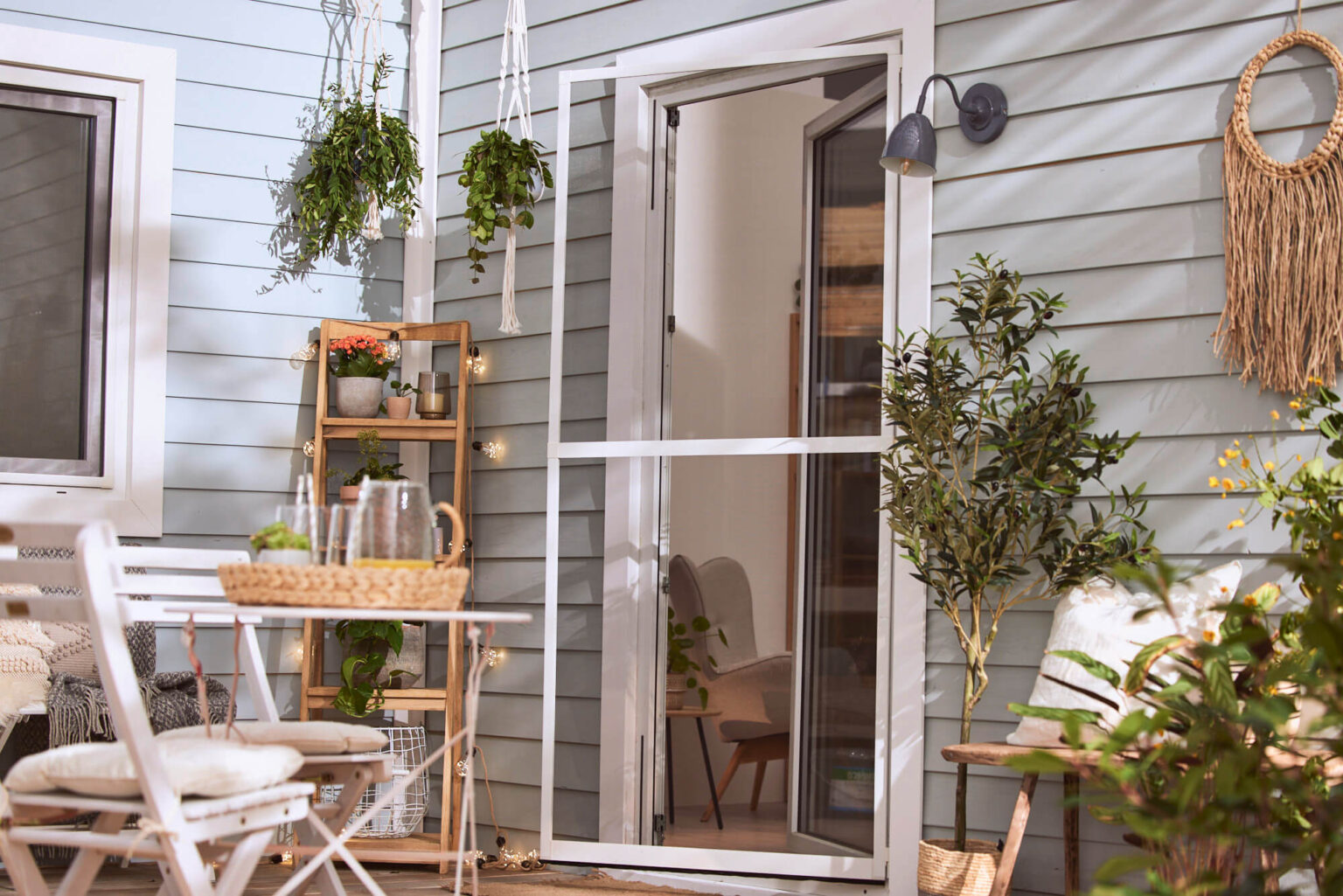 Outdoor-Terrasse-mit-mintgruener-Fassade-Pflanzen-und-Sitzmoebeln-Interior-Design-Sintje-Tramm