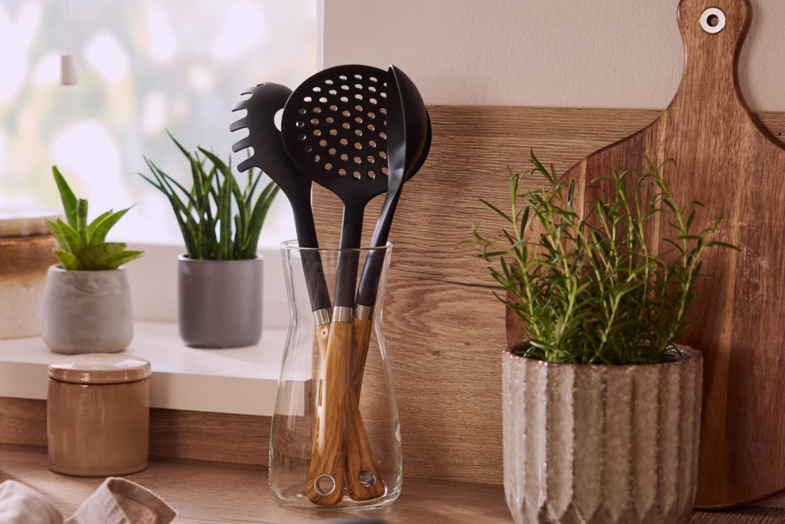 Kuechenutensilien-schwarz-in-Glasgefaess-auf-Holz-Arbeitsplatte-Interior-Design-Sintje-Tramm